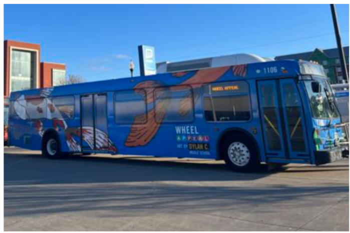 A Metro bus wrapped in a winning art design in a previous "wheel appeal" art contest. The design features a blue background with an orange koi fish and a white and orange koi fish