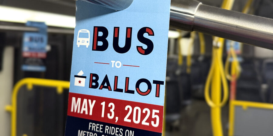 A hanger on the handrail of a Metro bus. It's a bright blue background with stylized text that says